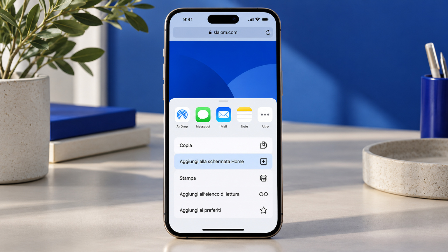 Un iPhone su una scrivania con il menu Condividi di Safari aperto e la voce «Aggiungi alla schermata Home» evidenziata