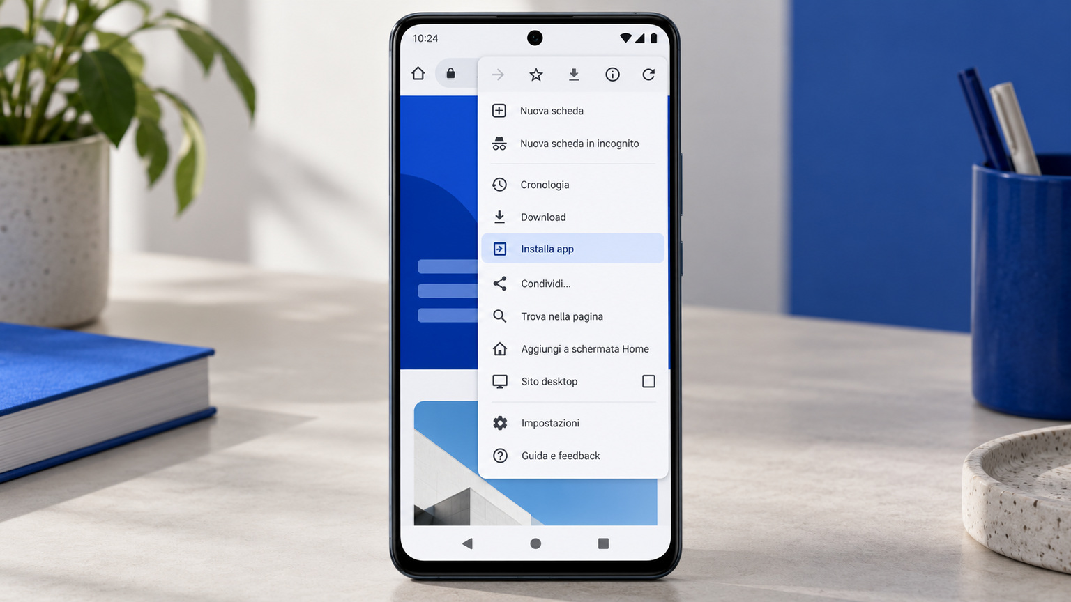 Un telefono Android su una scrivania con il menu di Chrome aperto e la voce «Installa app» evidenziata
